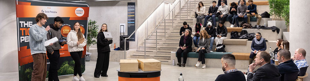 Students pitching to a panel in Elm House atrium