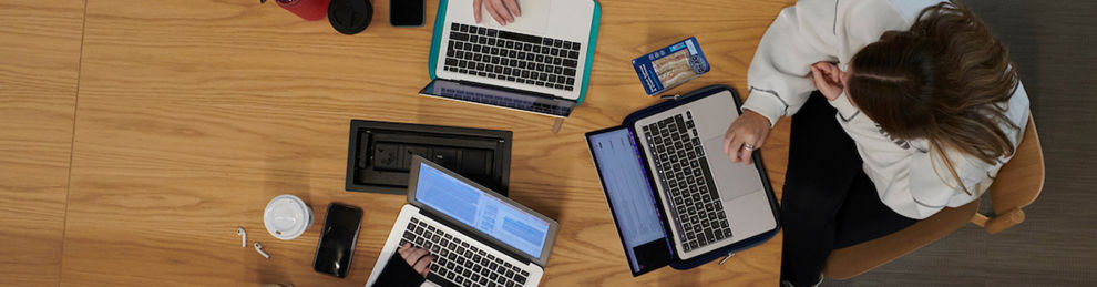 Laptops and students working on a group table