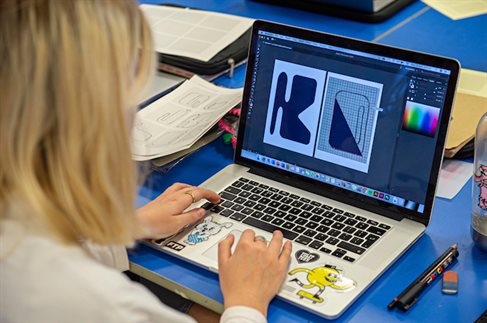 female applicant prepares online portfolio on laptop