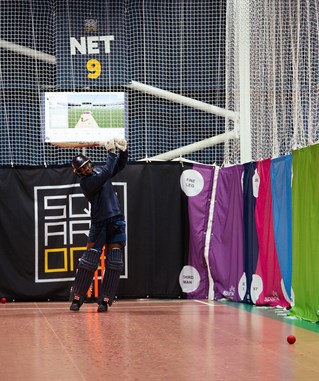 Cricketer batting in indoor facility