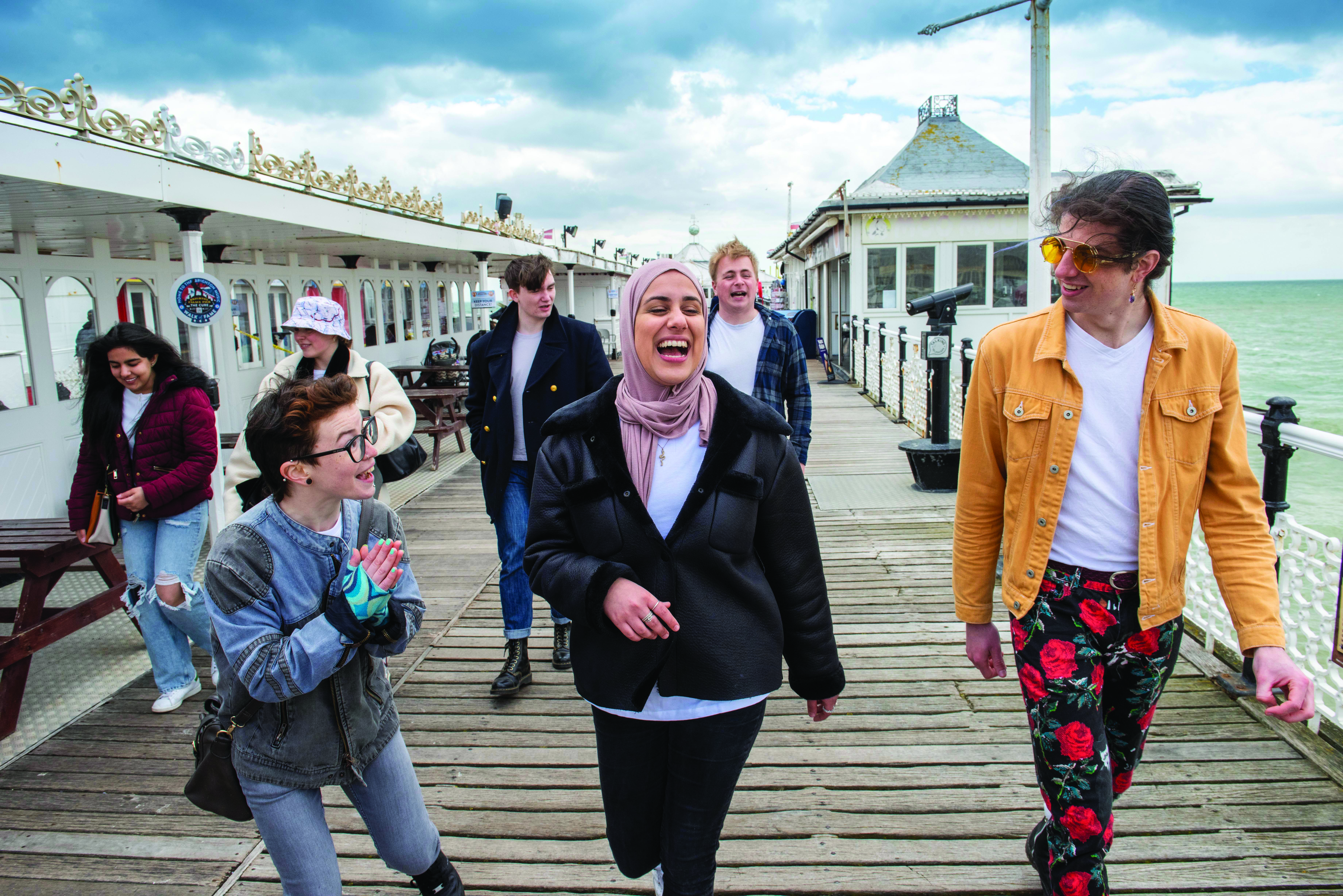 Students in University of Brighton t-shirts on the pier