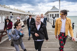 Students in University of Brighton t-shirts on the pier