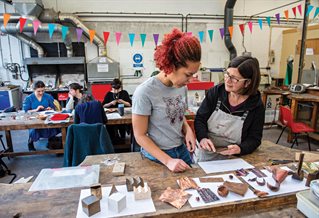 Art student and teacher discussing students work in the art classroom