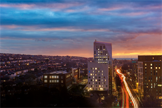 Silhouettes of the Mithras Halls of residence at sunset during rush hour