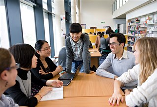 Six people having a discussion around a table