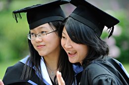 Two graduates in academic gowns, head to head