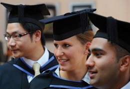 Three students in graduation gowns and caps