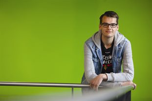 Student Andrew Baumann posing in front of a green screen