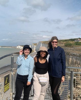 Three students stood in front of white cliff beach landscape