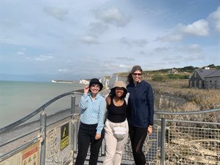 Three students stood in front of white cliff beach landscape