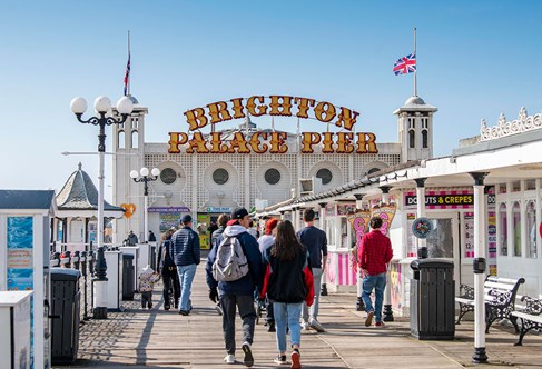 Busy Brighton pier entrance on a sunny day