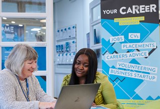 Member of the careers team meeting with student outside the Careers office