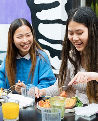 Students sitting outside of a cafe enjoying a meal together in Brighton lanes