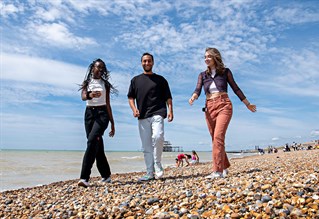 Students walking along Brighton beach