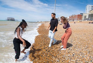 Three students enjoying the sea on Brighton beach