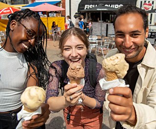 Three students enjoying ice cream on Brighton seafront