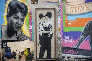 Graffiti on walls of Brighton including Banksy's kissing policemen. Photograph by Andy Weekes.
