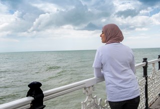 A student in a headscarf on the pier