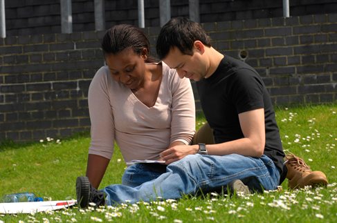 Two students sitting on the grass