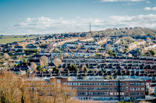 Aerial photograph of Mithras House on the university's Moulsecoomb campus, and surrounding houses climbing up the hill behind it. 