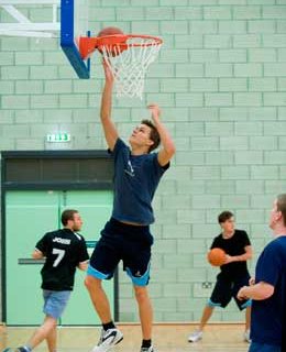 Students playing basket ball in the sports centre