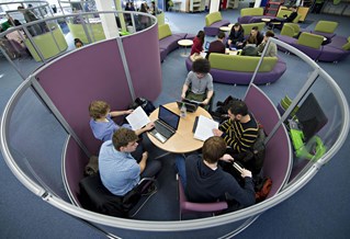 Five people having a discussion around a table