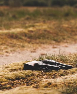 Revolver in the sand Photo by Jens Lelie on Unsplash