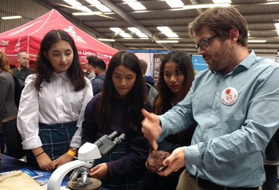 Three students watching a Big Bang experiment up close