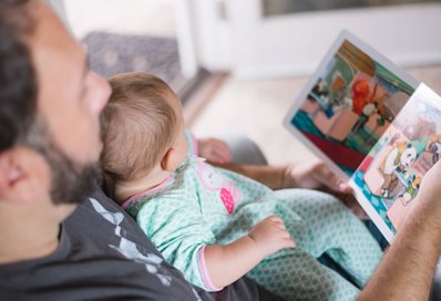 Parent reading to his child, photo by Picsea on Unsplash