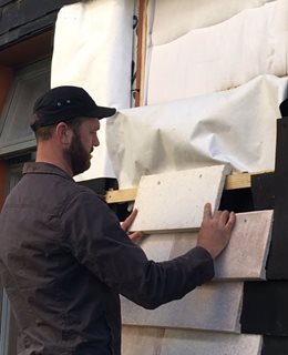 Putting new wall tiles on the Waste House