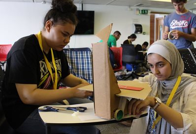 Summer school students constructing cardboard robots