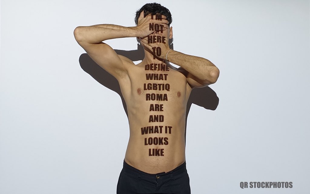 A man with the words I'm not here to describe what LGBTIQ Roma is displayed onto him
