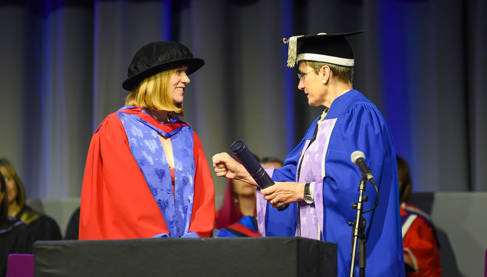 Becca Bland receiving her honorary doctorate from Vice-Chancellor Professor Debra Humphris