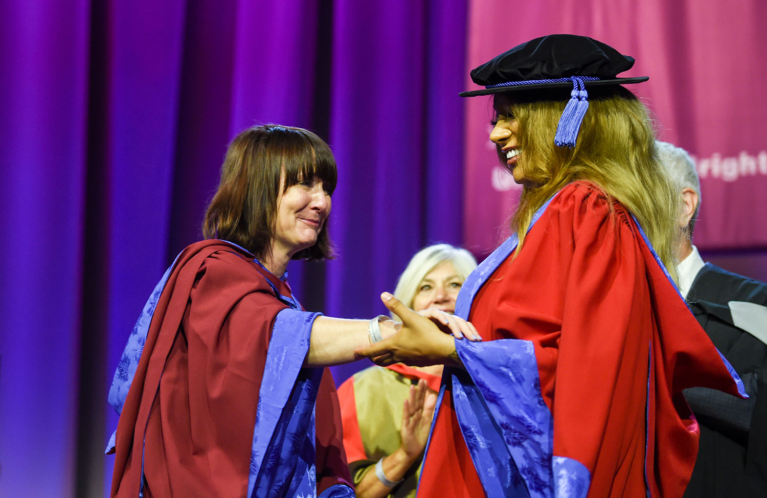 Dr Jess Moriarty embracing Munroe Bergdorf on stage