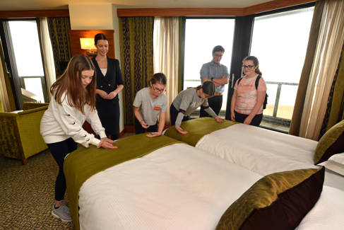 School pupils making finishing touches to making beds