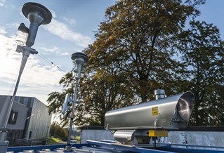 Advanced Air Quality research observatory, aluminium cylinders and mast mounted equipment on university building roofs.