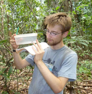 Dr Samuel Penny examining a frog in Madagascar