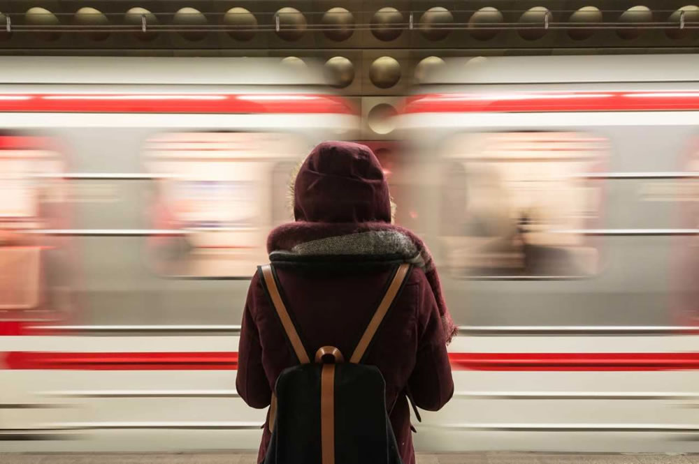 Woman stood on platform next to moving train