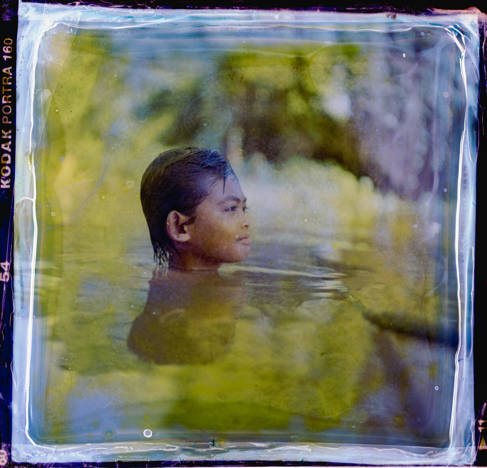 Child swimming in Tonle Sap Lake, Cambodia, picture by Lim Sokchanlina, chemically treated by Marcus Dymond