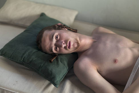 Man laying down in bed copyright Laura Pannack