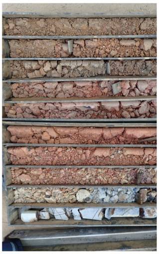 Drill core showing different colours and types of earth and rock