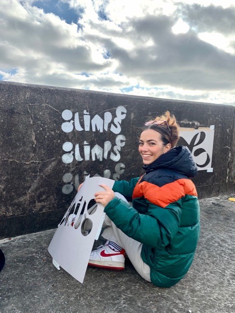 Student creating climate change mural