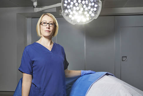 Professor Claire Smith in scrubs and gloves