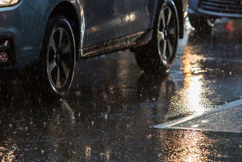 A wet road with cars on it