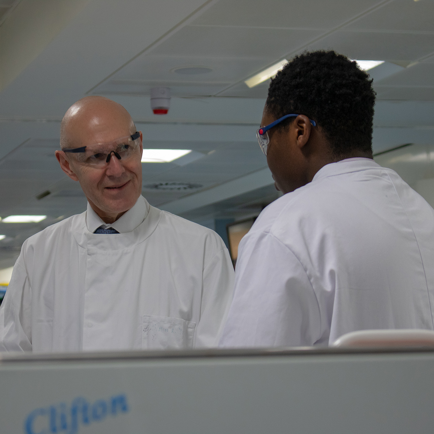 David Webb and a student, both in white coats and protective glasses