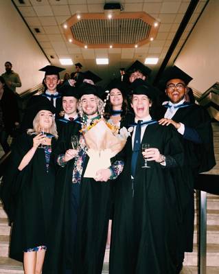 A group of graduates in the stairs in the Brighton Centre