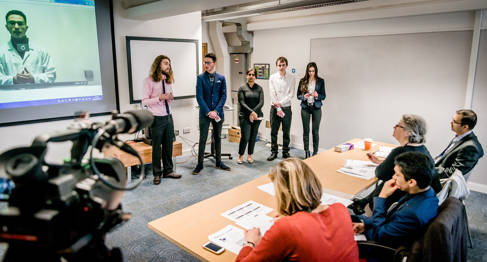 A group of students giving a presentation to a panel of judges