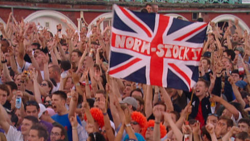 A close up of the crowd on Brighton Beach with a Normstock II flag