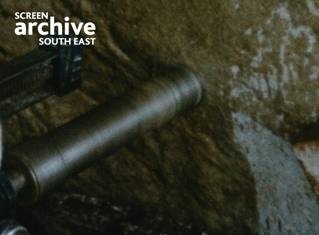 Grainy 50s colour film shot of large drill going into stone at Stonehenge. Courtesy Screen Archive South East and the Phillips family.