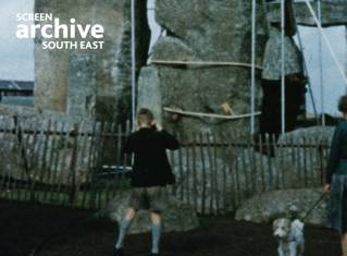 Grainy 50s colour film shot of young boy in shorts photographing engineering work at Stonehenge. Courtesy Screen Archive South East and the Phillips family.